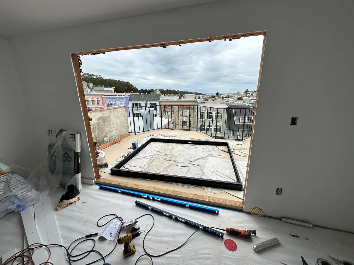 A rough window opening mid-renovation at 21st Ave, looking over Richmond District rooftops